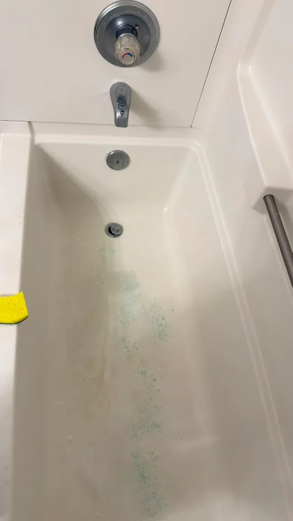 Bathtub with residue and staining before cleaning by Dolane Cleaning Services